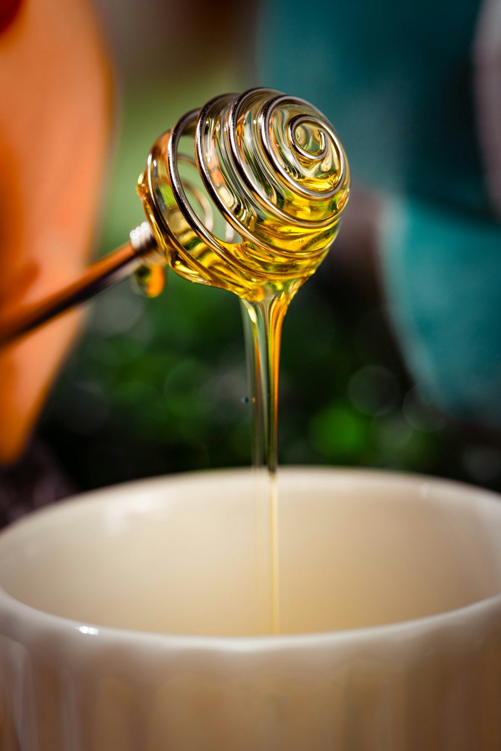 Honey dripping from a wooden dipper