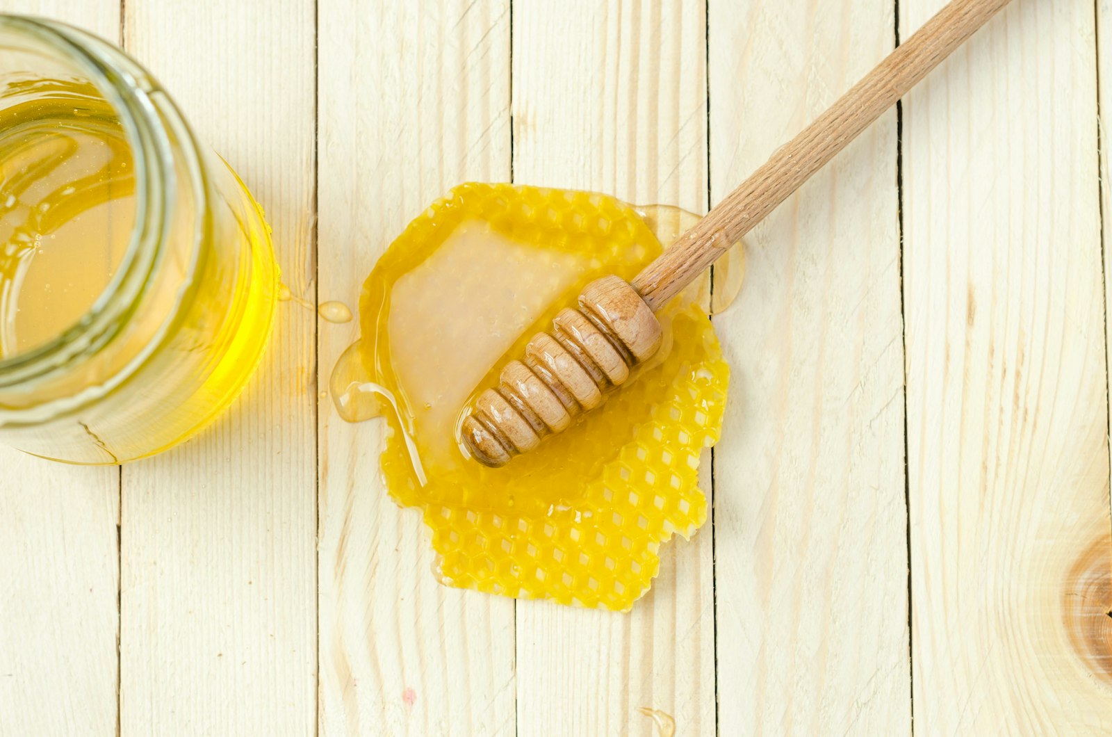 Honey dipper resting on honeycomb